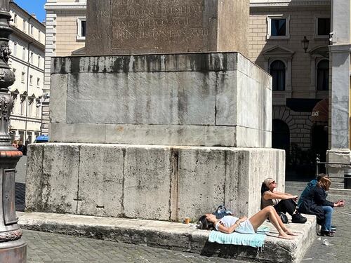 Piazza di Montecitorio, teli da mare e piedi scalzi: lo sfregio all'obelisco