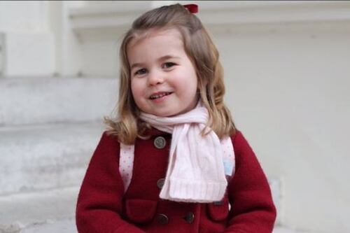 Charlotte veste di rosso e sorride al suo primo giorno d'asilo
