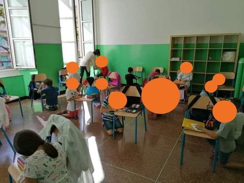 Niente banchi, i bambini scrivono in ginocchio sulle sedie. La foto shock in una scuola di Genova